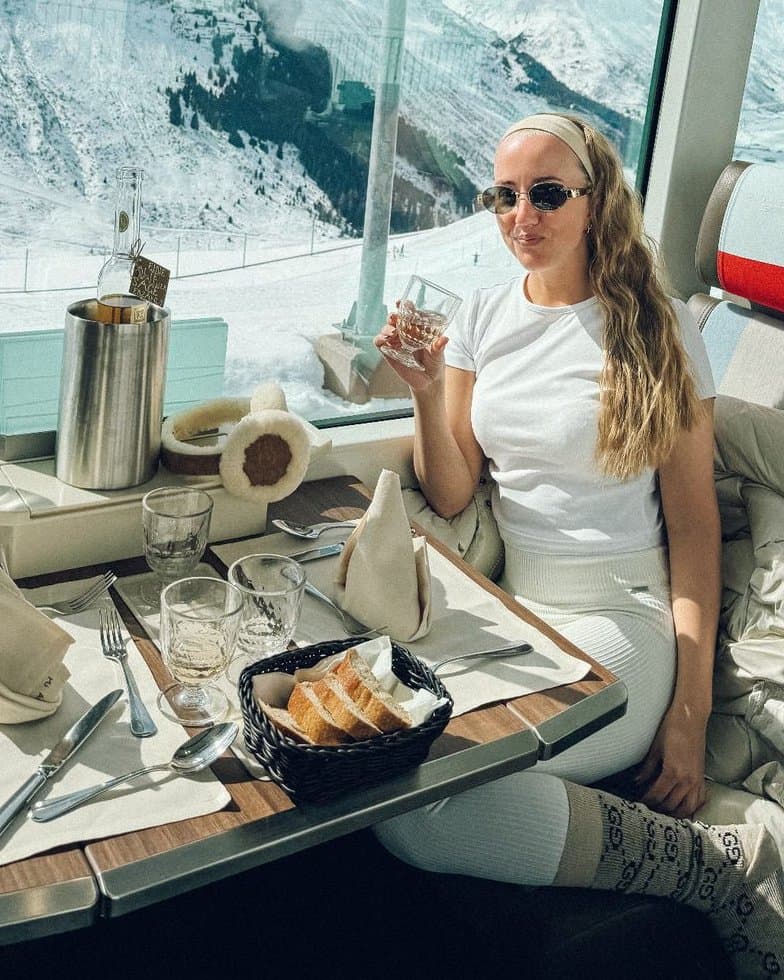 Marie med ett glas vin på tåg genom de schweiziska alperna